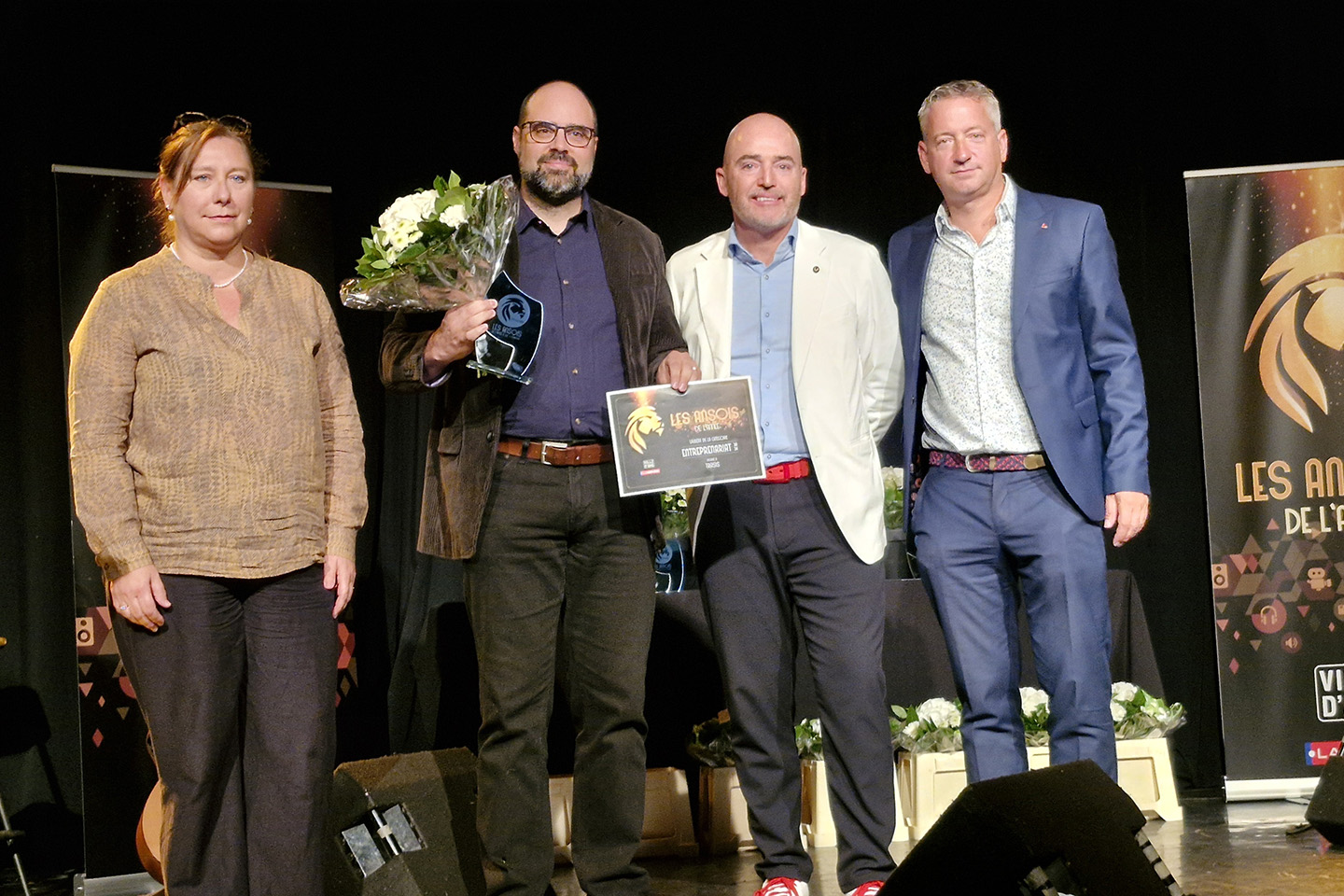 Lauréat du prix Entrepreneuriat aux Ansois de l'année 2024 recevant son trophée et bouquet de fleurs